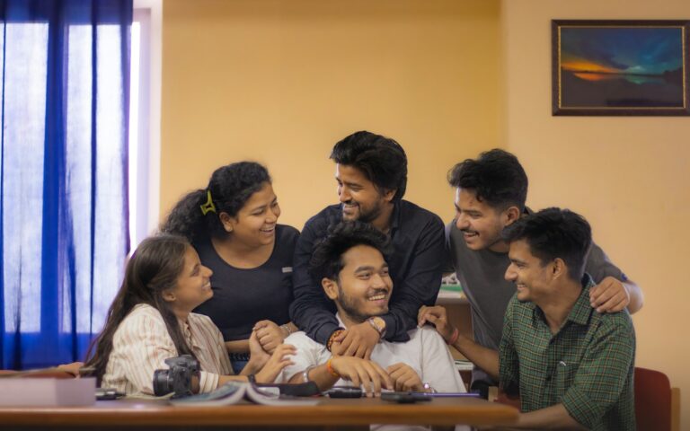 Indian college students collaborating on laptops in a classroom